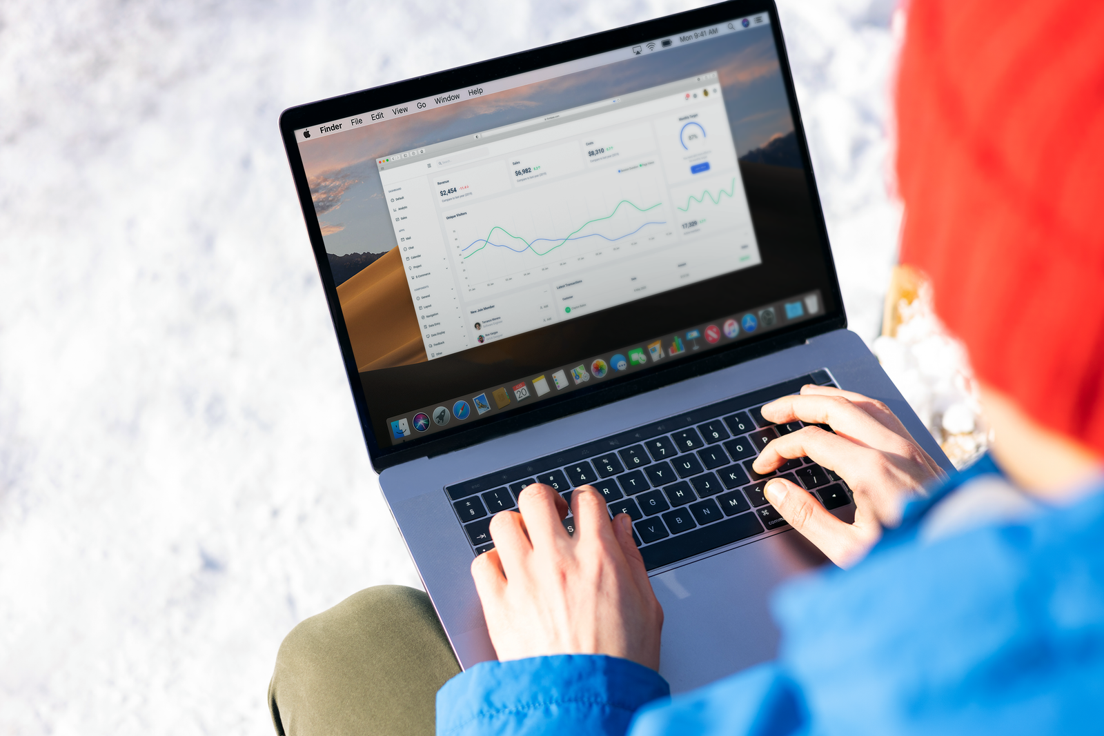 Hands on a laptop showing an analytics dashboard
