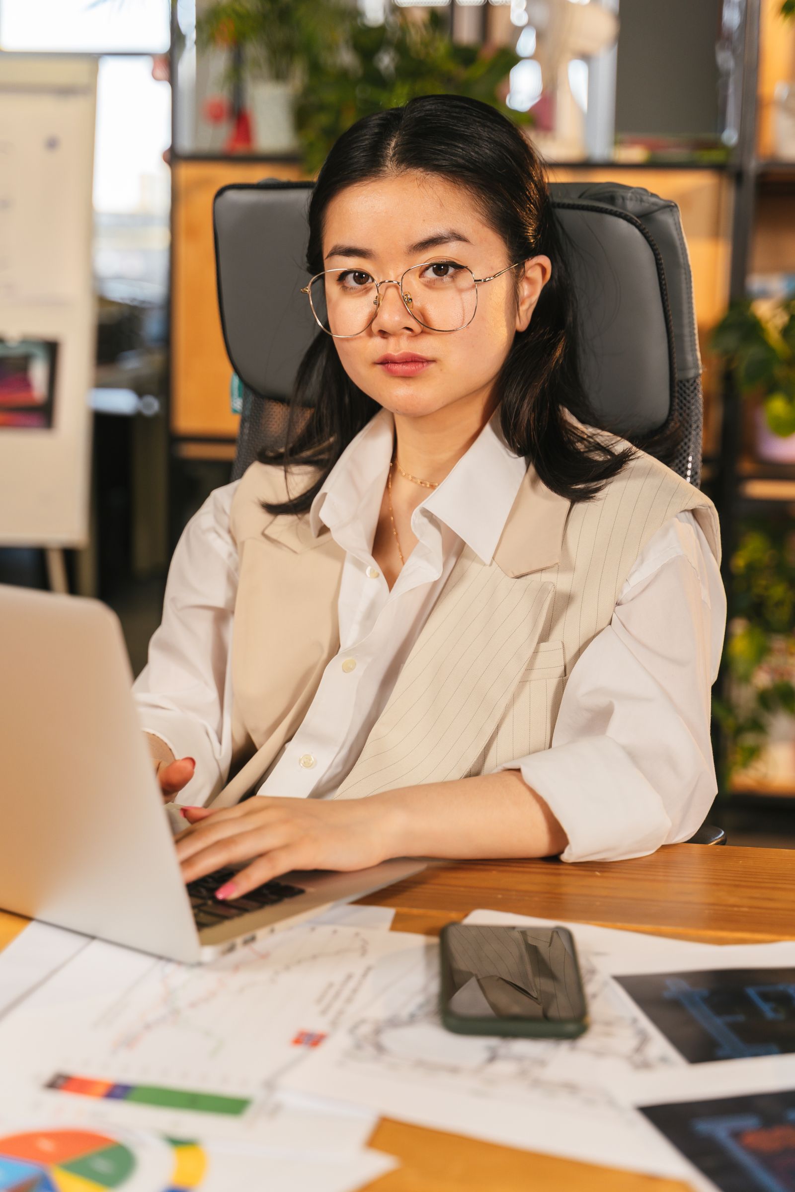 A strategist at her desk, smiling at a laptop